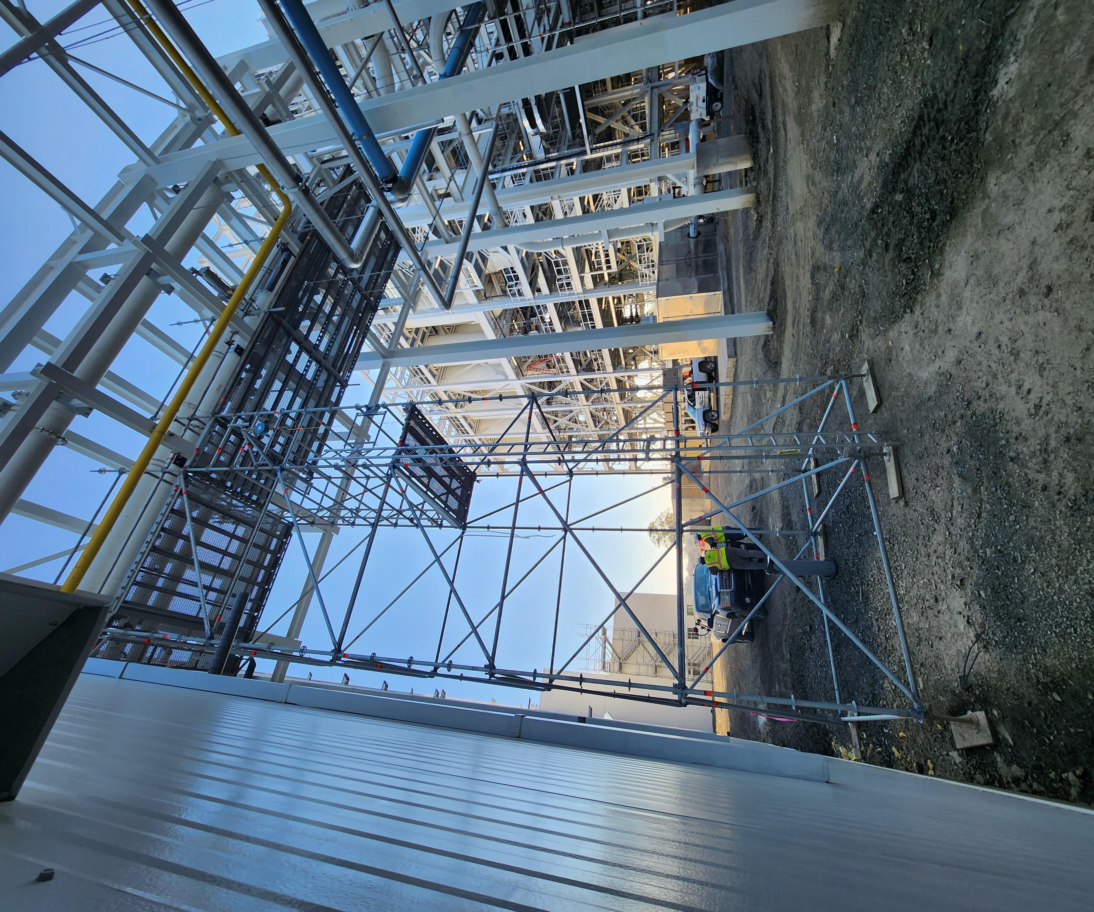 Exterior industrial scaffold access tower beside a facility structure